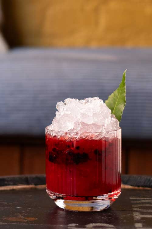 A fresh cocktail sat on top of a barrel