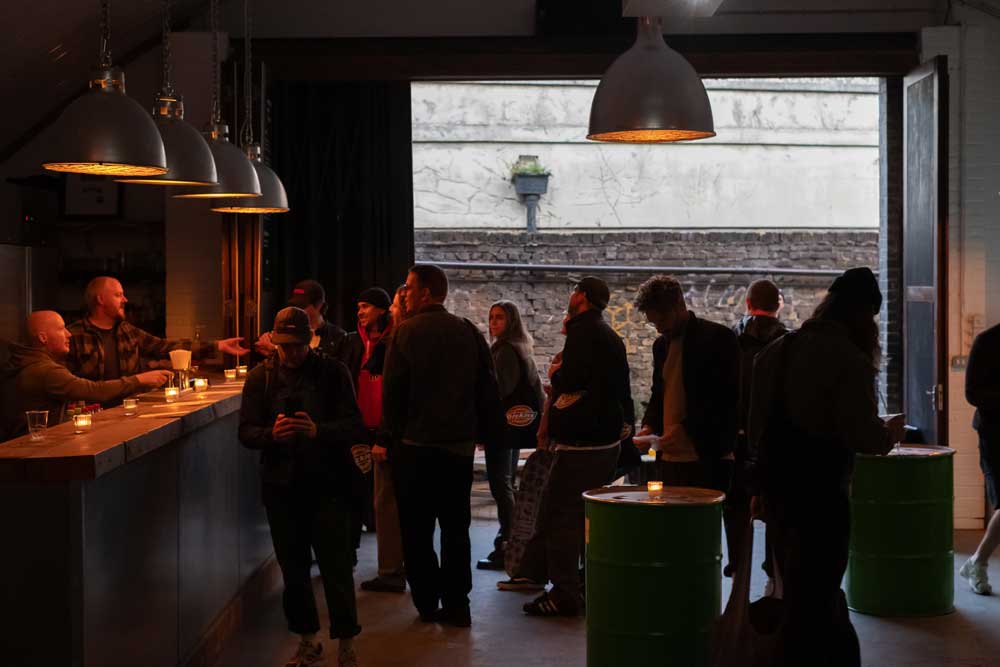 People stood ordering drinks in a bar inside a railway arch