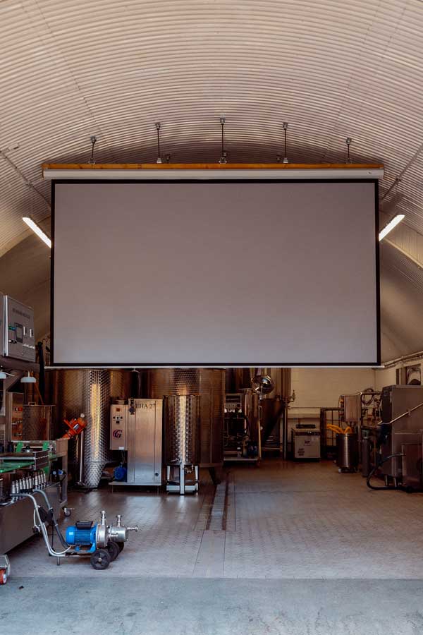 A large projector screen in a railway arch